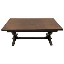 20th century oak drawer leaf extending dining table, two foliage carved baluster supports on sledge feet joined by floor stretcher 