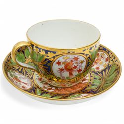 19th century teacup and saucer, possibly Coalport, decorated with panels of flowers on a cobalt blue ground with gilt decoration; together with two other teacup and saucer pairs, one with hand painted landscape decoration 