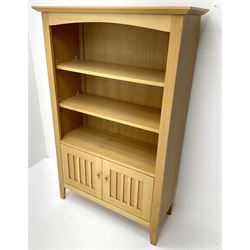 Light oak open bookcase, two shelves above two cupboard doors, stile supports