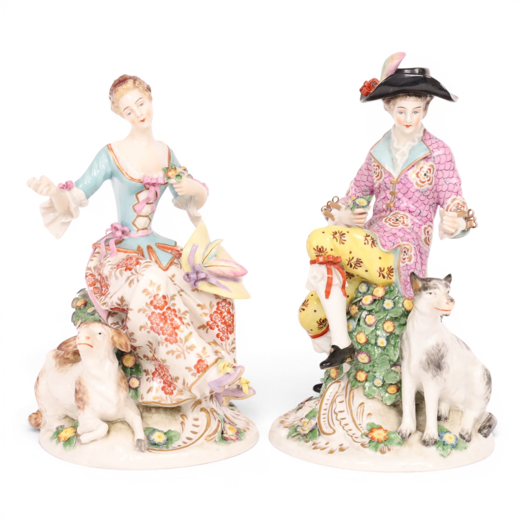 Pair of 19th century Samson figures, the gentleman wearing a wide brimmed hat with a dog, the lady with a sheep by her side, both figures seated upon a floral encrusted pillars with gilt scrolling base, H22cm