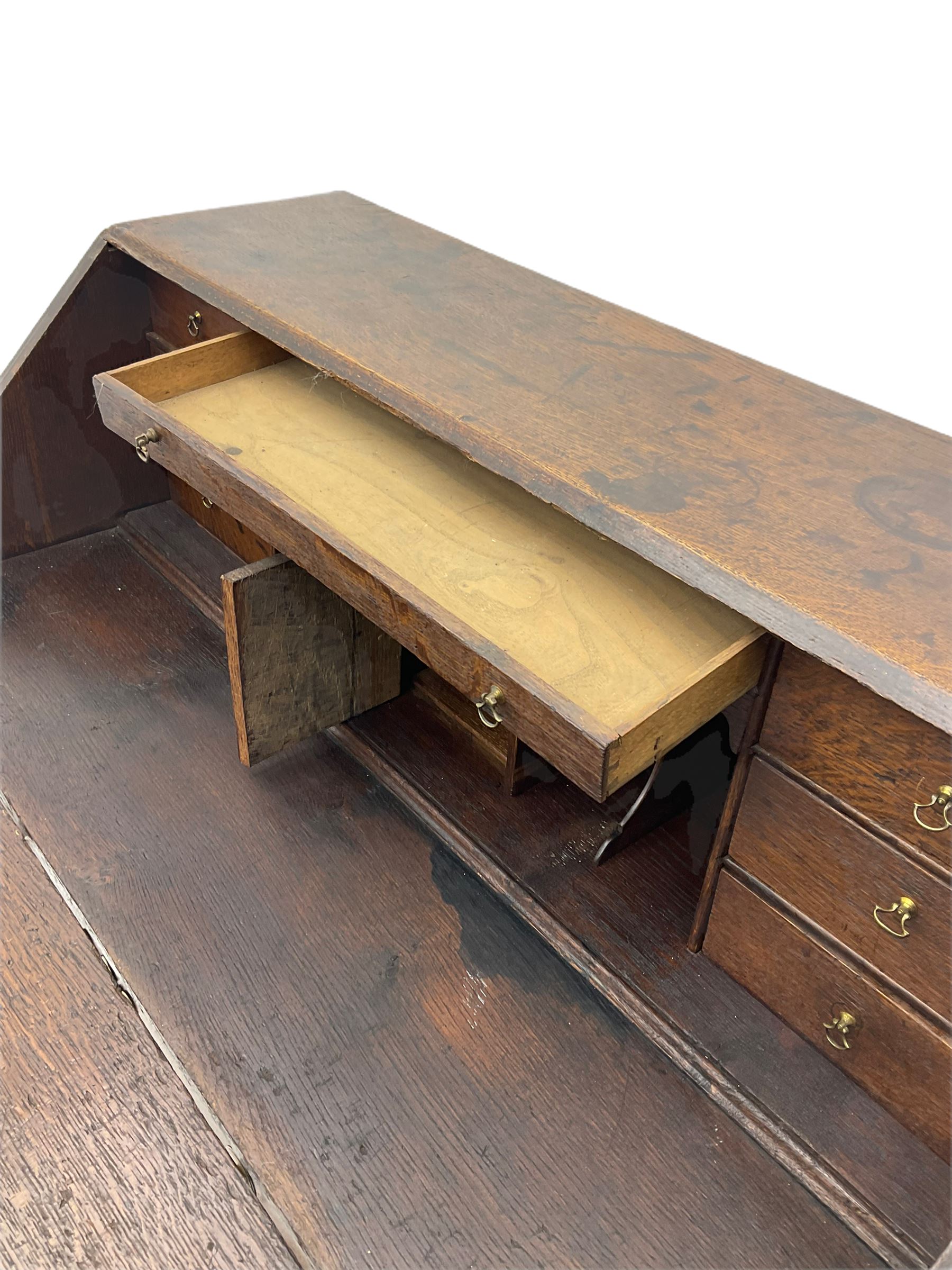 Georgian oak bureau, fall front enclosing fitted interior, four long graduating drawers, on bracket feet