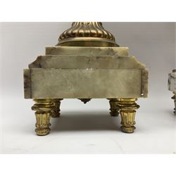 Pair of 19th century gilt metal twin handle urns, raised upon stepped marble bases, H36cm