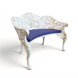 Victorian revival cast two seat garden bench, scrolling lattice back with flower heads, terminating to rams heads arms, curved pierced seat, finished in antique white paint