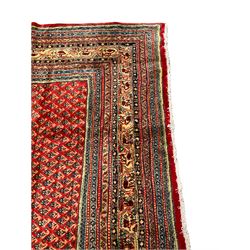 Persian Arraq red ground carpet, the field with all-over Boteh motifs, the guarded ivory border with repeating geometric patterns