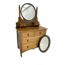 Early 20th century oak dressing chest, circular bevelled swing mirror over two small trinket drawers, fitted with two short and two long drawers, together with an oval wall mirror