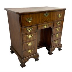 Early 18th century Queen Anne figured walnut kneehole desk with secretaire drawer, moulded and book matched top with walnut band, the top drawer with fall front enclosing small drawers and pigeon holes, fitted with nine drawers and central recessed cupboard, on ogee bracket feet