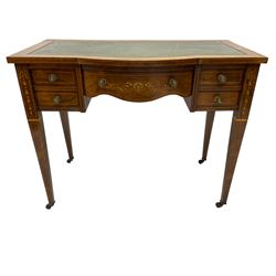 Edwardian inlaid rosewood writing desk, break bow-front with tooled and gilt green leather inset, fitted with five drawers, the central drawer with scrolling inlays, on square tapering supports inlaid with ribbons and flower heads, on brass and ceramic castors