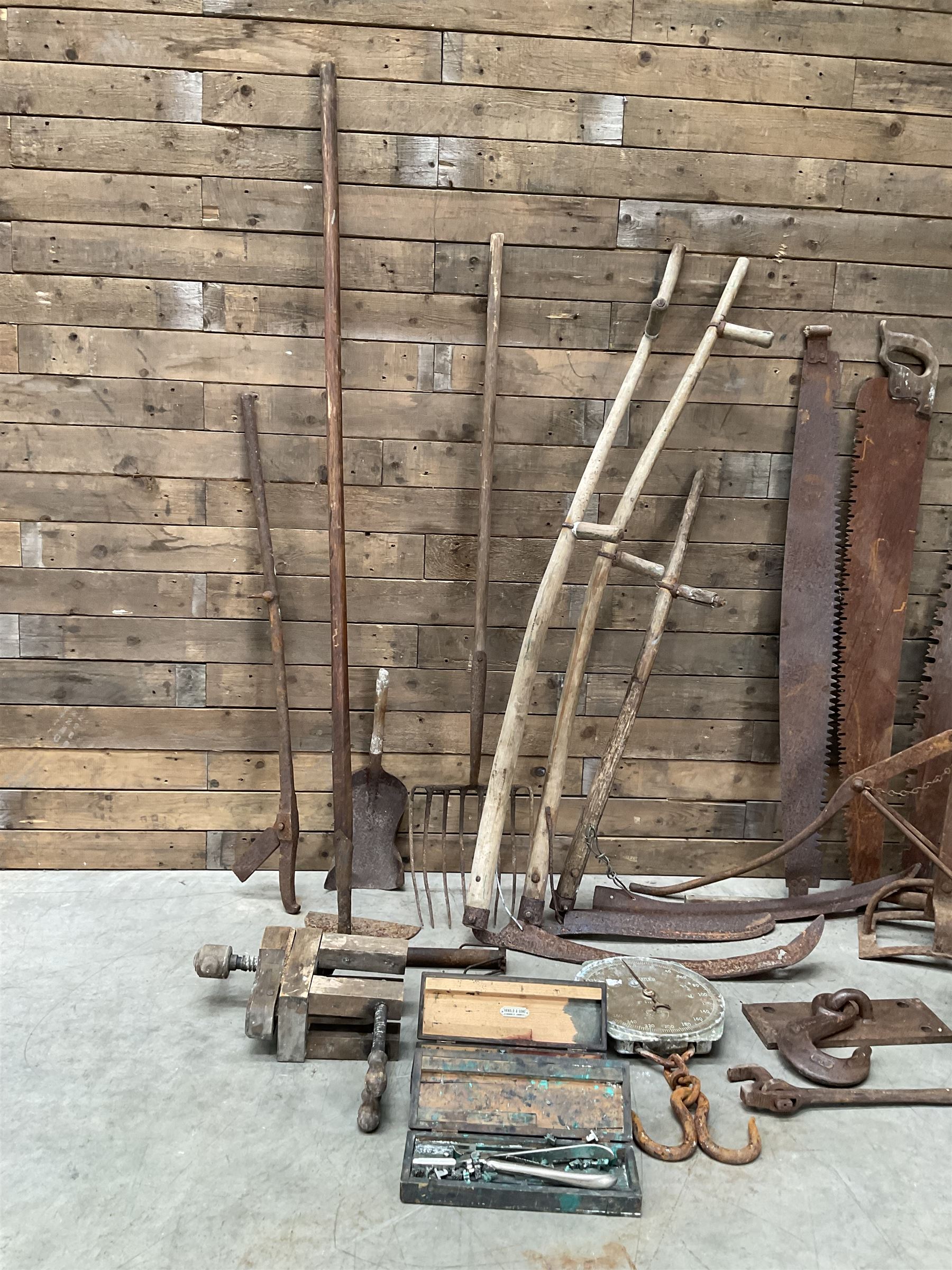 Large quantity of vintage hand tools including scales, scythes, saws etc