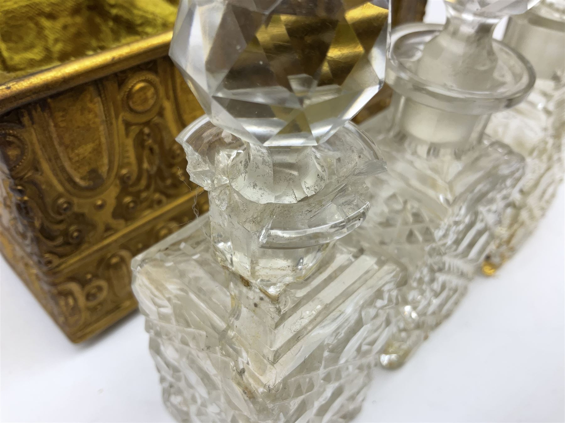 19th century brass repoussé perfume box, the ornately decorated casket with hinged domed cover lifting to reveal gold velvet lined interior containing three glass scent bottles, H14cm W15cm D7cm