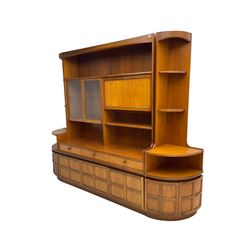Nathan - mid-20th century teak wall display unit, fitted with glazed doors, fall-front drinks cabinet and three short drawers, with pair matching corner side units, shelf over double cupboard