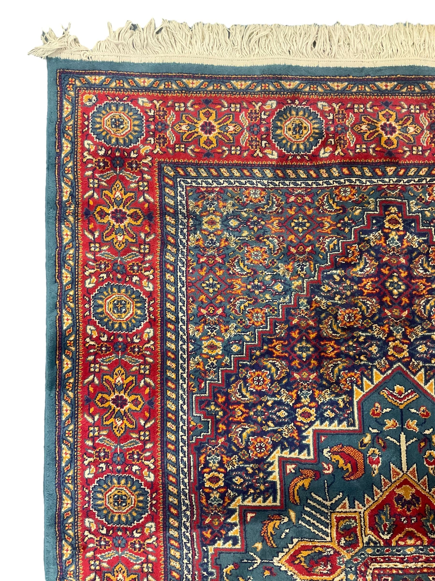 Persian design blue ground rug, the field decorated with Herati motifs and central floral medallion, repeating guarded border decorate with flower heads and trailing leafy branches 