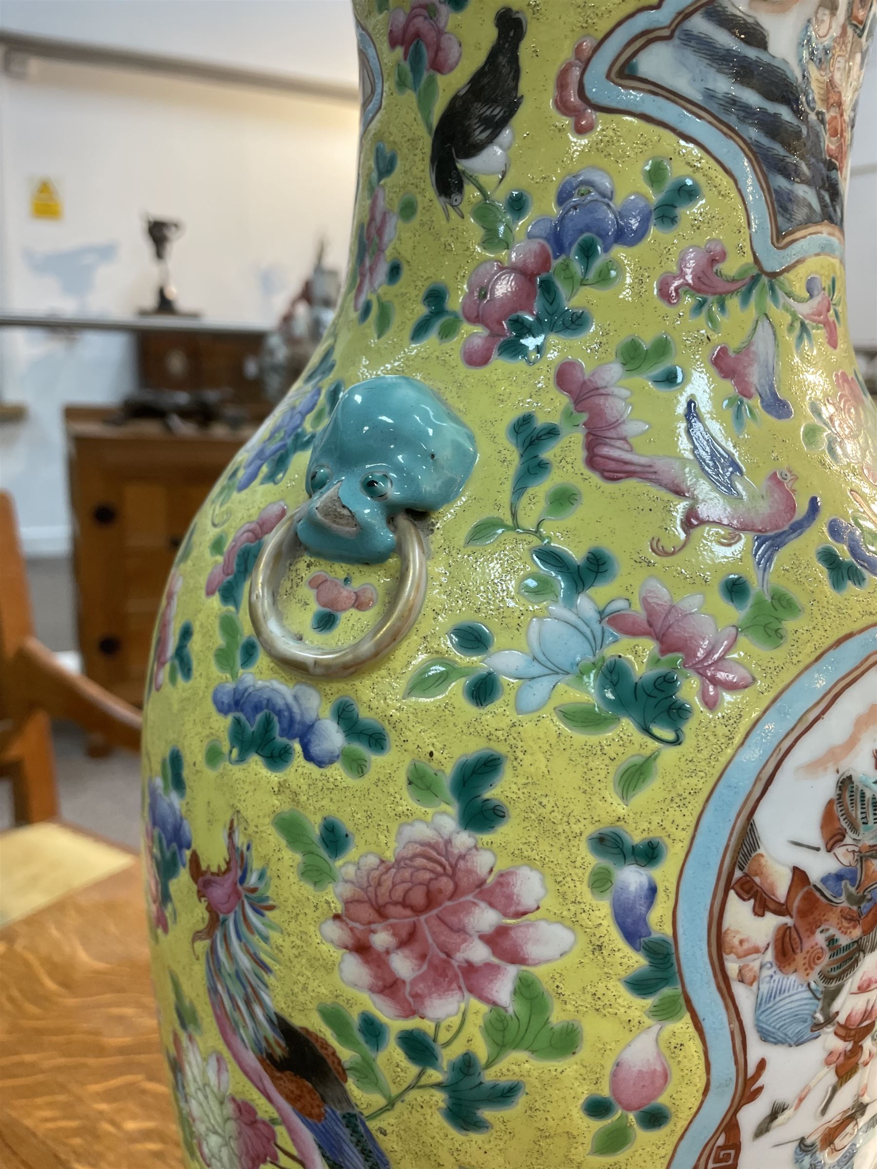 19th century Chinese famille rose yellow ground porcelain vase, of baluster form with twin applied mask ring handles, the body decorated with two shaped reserves mounted with dragon heads, depicting warriors at battle and at court, the neck with two smaller conforming figural reserves, upon a yellow ground decorated with exotic birds amidst scrolling blossom, H45.cm