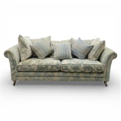 Alstons - 'Lowry' three seater settee, loose cushioned back and seat with additional cushions upholstered in silver and blue floral fabric, supported on square feet with chrome castors to the front