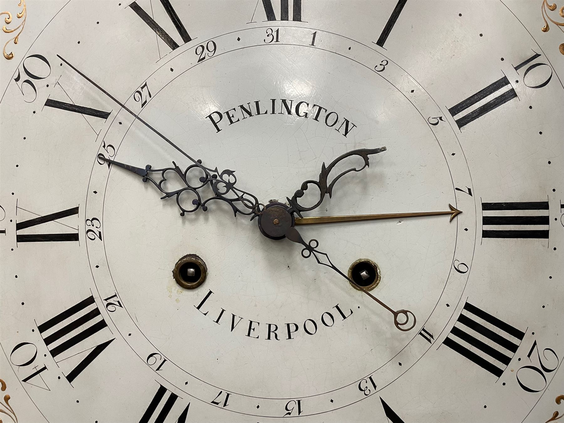 Penlington of Liverpool – early 19th century 8-day mahogany longcase clock, swans neck pediment with three turned wooden finials and verre eglomise panels, trunk with reeded columns and wavy topped door, plinth with canted corners on bracket feet, painted break-arch dial with Roman numerals and five-minute Arabic’s, centre sweep calendar and seconds hands, blue steel serpentine hands, signed beneath a painted rolling moon in the arch PENLINGTON, LIVERPOOL, eight day four pillar movement, anchor escapement and rack striking on a bell. With pendulum and weights.  The Penlington family were prolific clockmakers in 19th century Liverpool working from several addresses in the city, also recorded as chronometer and chronograph makers.