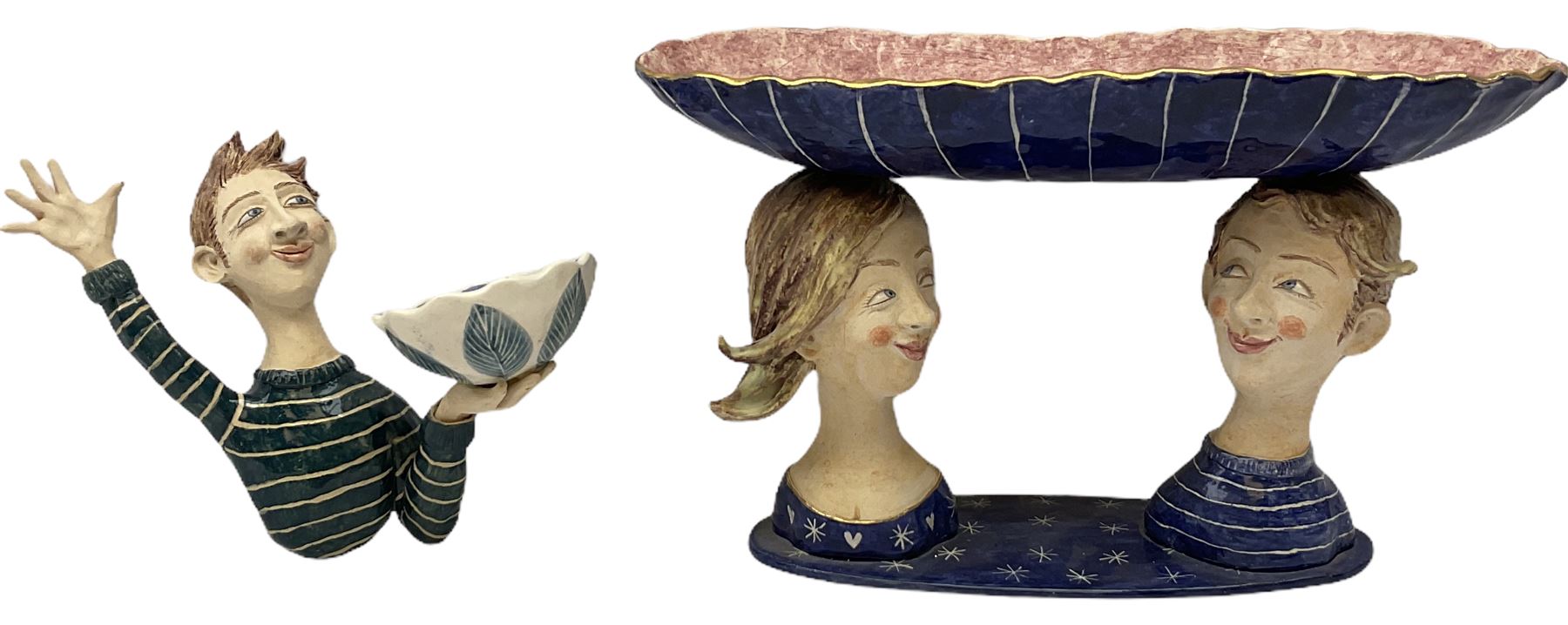 Ceramic 'girl and boy dish', by Helen Kemp, an oval dish with a mottled pink ground and gilt edging upon the sculpted heads of a girl and a boy, together with a 'boy sconce', by Helen Kemp, a sculpted boy holding a small bowl with foliate decoration, both with the artist's mark beneath.