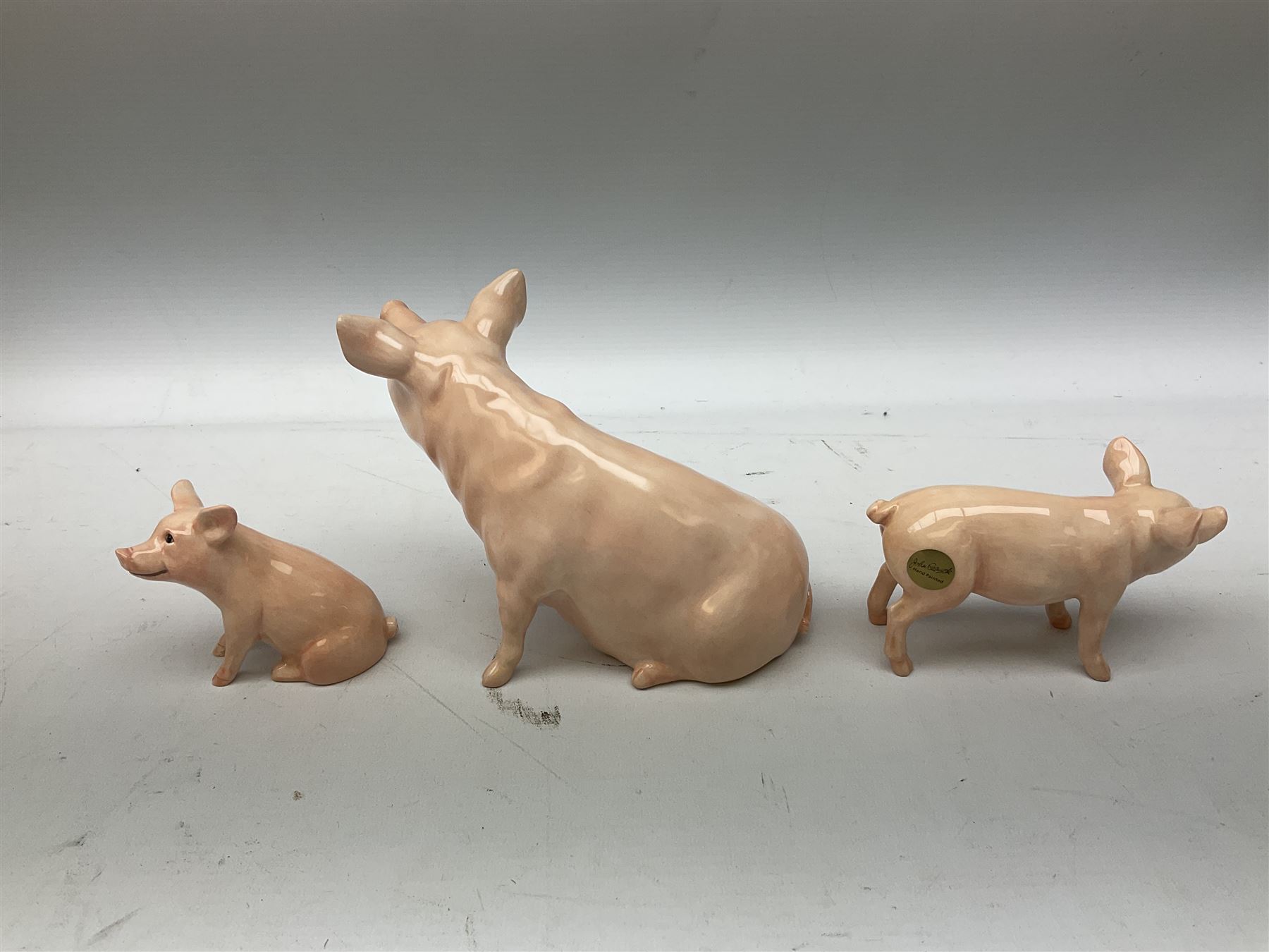 Collection of Beswick pig figures, to include John Beswick Little Likeables ‘Hide and Sleep’, white boar pig and John Beswick trio of pigs, all marked beneath (5)