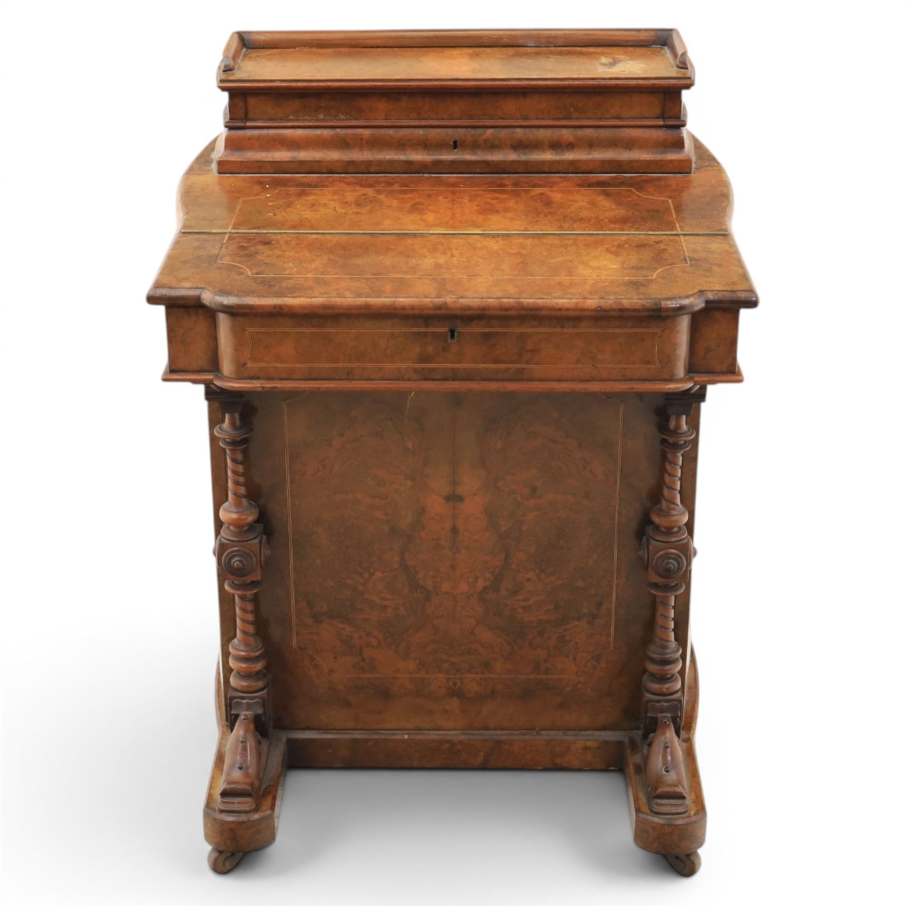 Victorian burr walnut Davenport, with hinged stationary top and slope, pull out writing surface with tooled green leather inset top, carved and turned front supports, flanked by two cupboard doors, raised on castors 