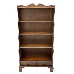 Late 20th century mahogany waterfall bookcase, fitted with two drawers, on bracket feet