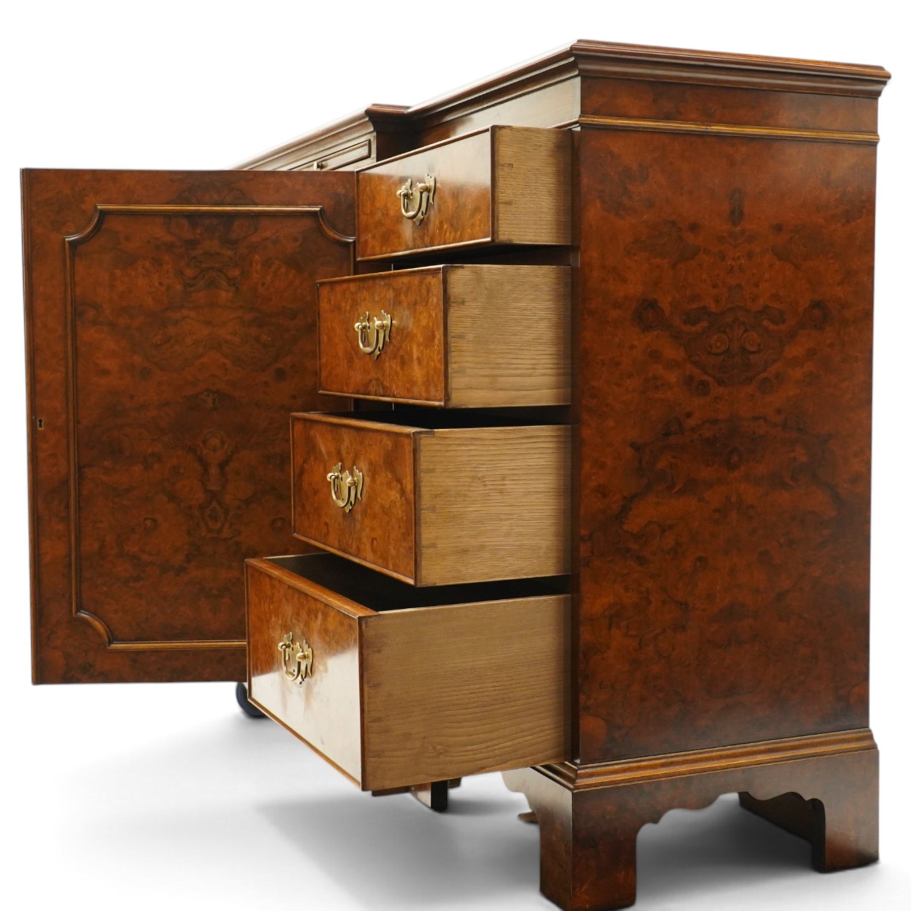 Georgian design figured and burr walnut breakfront sideboard, shaped rectangular top inlaid with crossbanding and stringing, fitted with central brushing slide over cupboard enclosing single adjustable shelf, flanked four graduating cock-beaded drawers to each side, raised on bracket feet