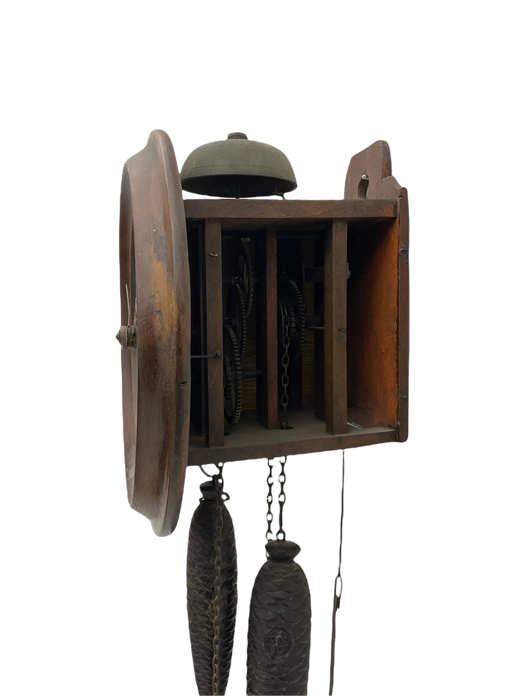 A German 30-hour chain driven wooden framed Postman’s Alarm clock, sounding on a bell, with internal wooden movement plates and brass train wheels, 7” chapter ring with roman numerals, minute track and half hour markers, with steel hands (minute hand a replacement) and alarm setting disc to the centre, with a 10-1/2” oak bezel and hinged side viewing doors. With weights and pendulum.




