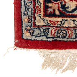 Persian crimson ground rug, interlacing floral stems linking ivory palmettes, rosettes and serrated leaves, within a navy floral border flanked by ivory patterned guards