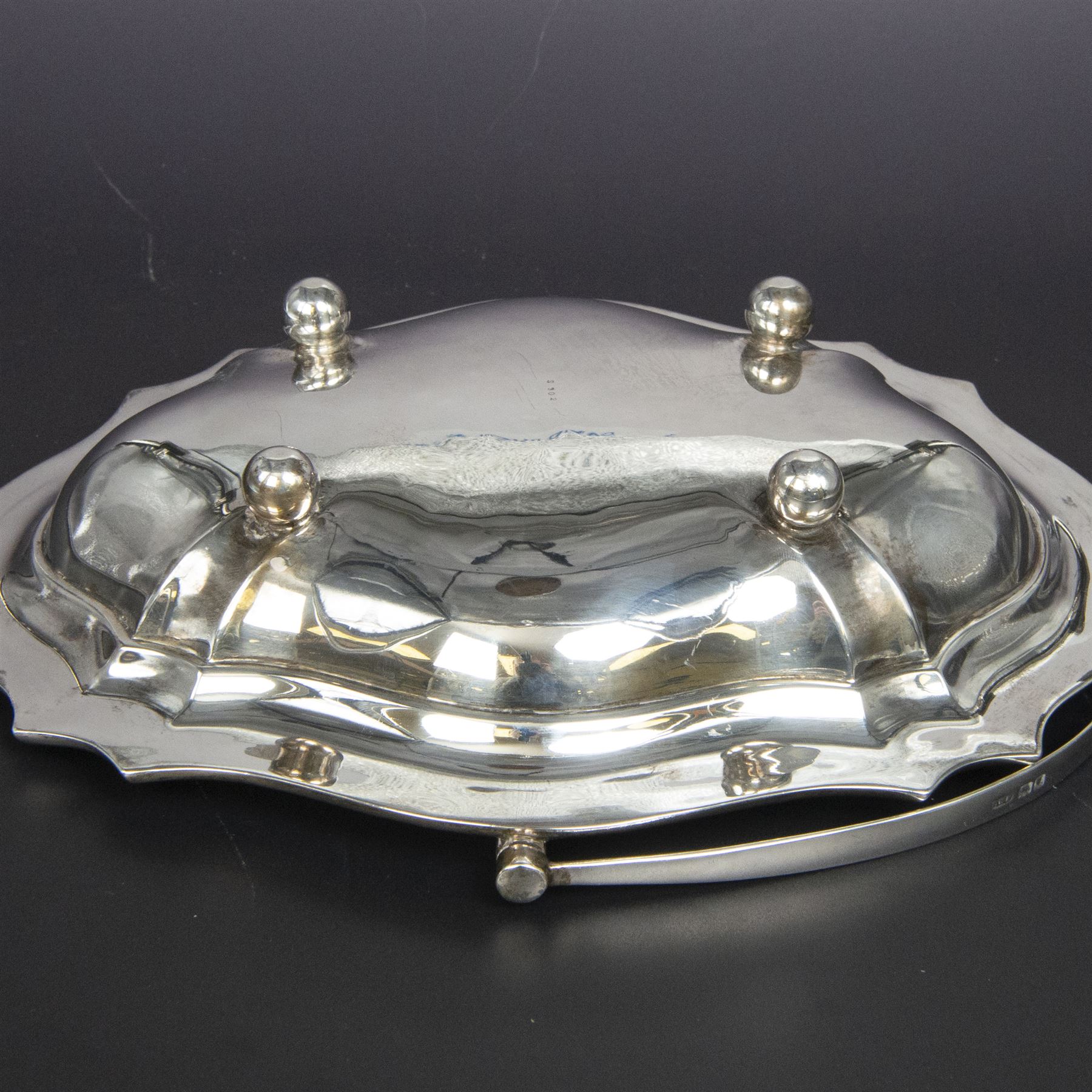 Early 20th century silver swing handled basket, of oval form with shaped rim and upon four bun feet, hallmarked C W Fletcher & Son Ltd, London 1918