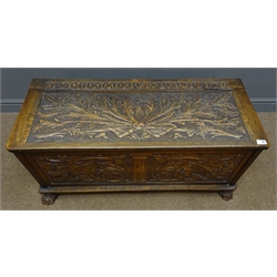  19th century carved oak chest, front carved with trailing foliage and flower head, central fluted Ionic column, hinged lid carved with leafage and initialed 'E.A', carved paw feet, W107cm, H48cm, D44cm  