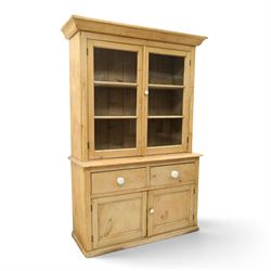 Victorian stripped pine and glazed dresser, projecting ovolo cornice over glazed doors enclosing two shelves, the base fitted with two drawers over panelled cupboards with ceramic handles, on moulded skirted base