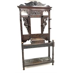 Victorian oak carved hall stand, complete with ten hooks either side of central mirror, raised on turned supports joined with under tier 