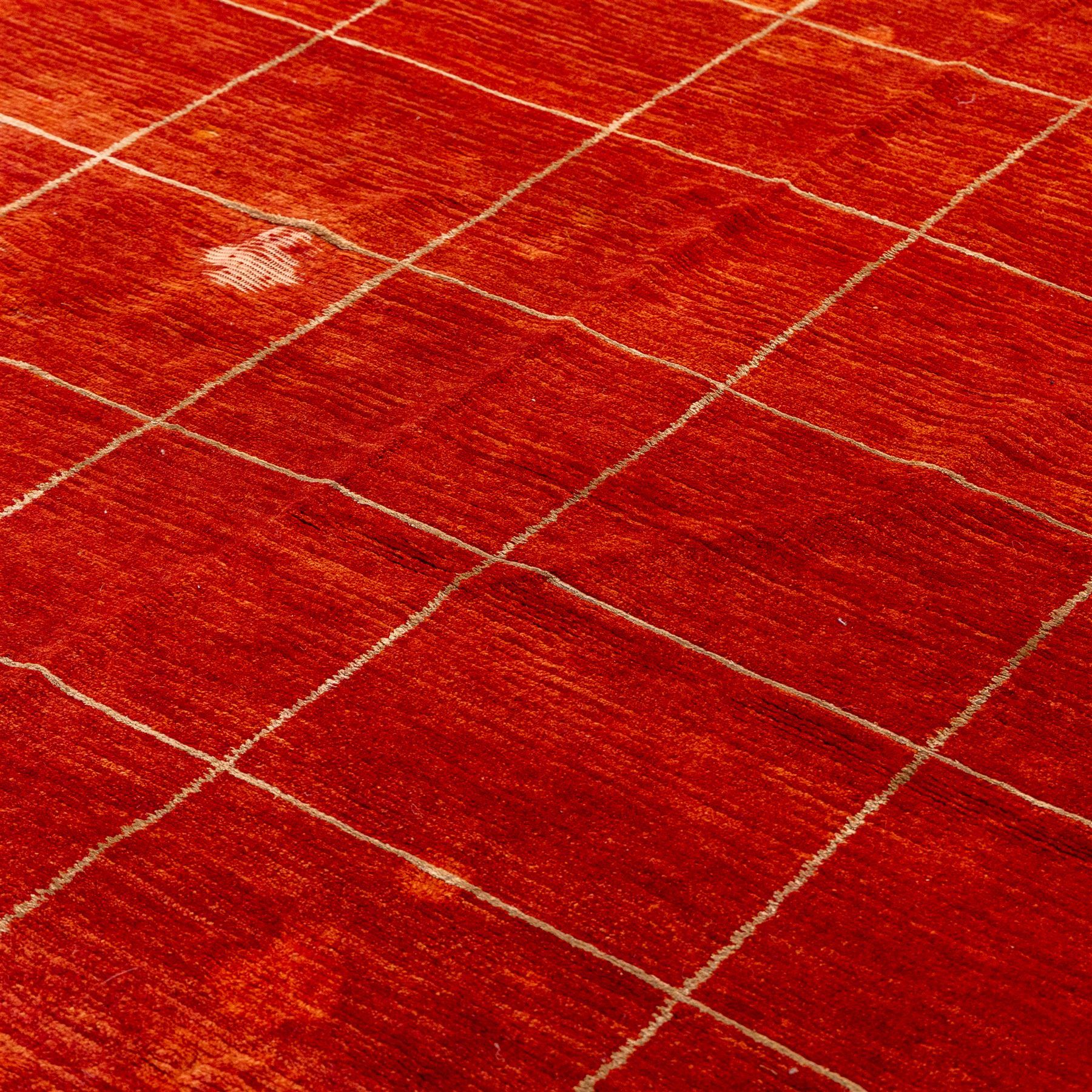 Two contemporary Moroccan Berber hand-woven rugs, deep madder red field of plain design, 199x153cm, other with deep madder red field with a simple lattice of ivory lines forming panels with some tonal variation, 190x146cm 