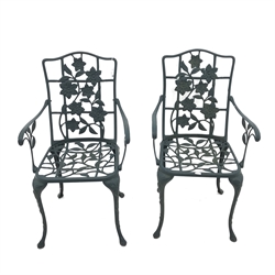 Circular wrought metal garden table, scrolling supports, painted green finish (D91cm, H69cm) and pair armchairs (W53cm)