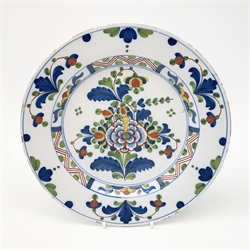A mid 18th century English Delft plate, painted in polychrome colours with flowers and leaves, D24cm.