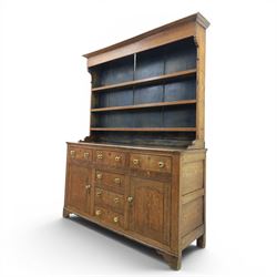 18th century Georgian oak dresser and rack, three back-boarded plate shelves, above six drawers and two cupboards, raised on bracket feet