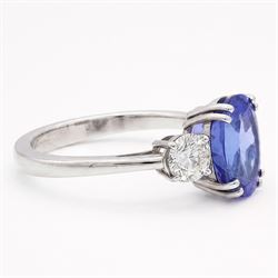 Platinum tanzanite and diamond three stone ring, single oval cut tanzanite of approx 3.55 carat, with a round brilliant cut diamond set either side, total diamond weight approx 0.80 carat