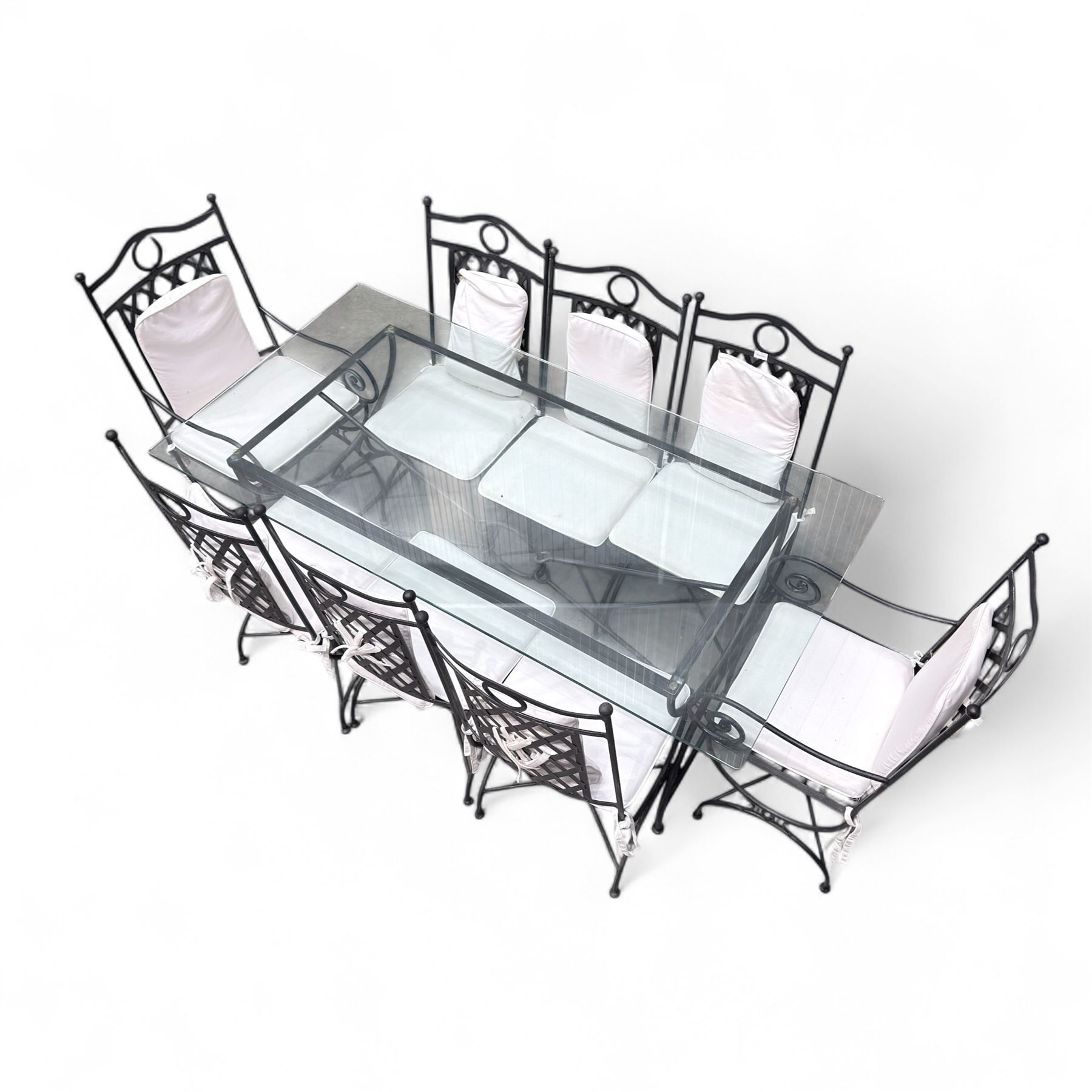 Wrought steel rectangular conservatory dining table, with glass top; and six, four side and two armchairs, with lattice backs and X framed bases, loose cushions
