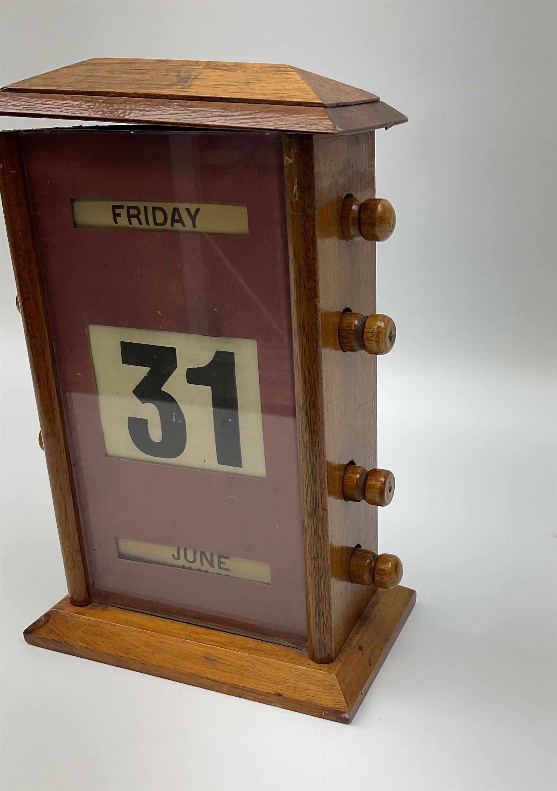 An early 20th century oak perpetual desk calendar, with three glazed apertures for day, date and month, H20cm