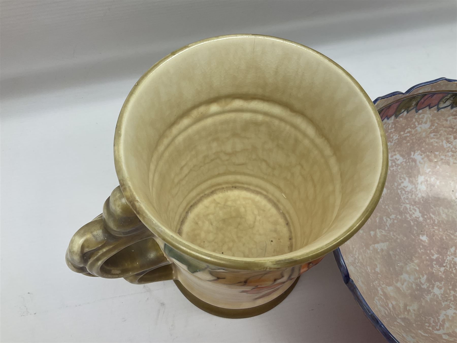 Charlotte Rhead for Crown Ducal ceramics, comprising coffin shaped vase depicting a woman in 1920s dress, a vase with handle, decorated with autumn leaves and a bowl, decorated with flowers and berries, with printed and signed marks beneath, coffin vase H24cm