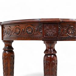 Mahogany demi-lune console table, moulded top over flower head guilloche decorated frieze, on turned and acanthus carved supports with fluted decoration, united by shaped stretchers with central finial 
