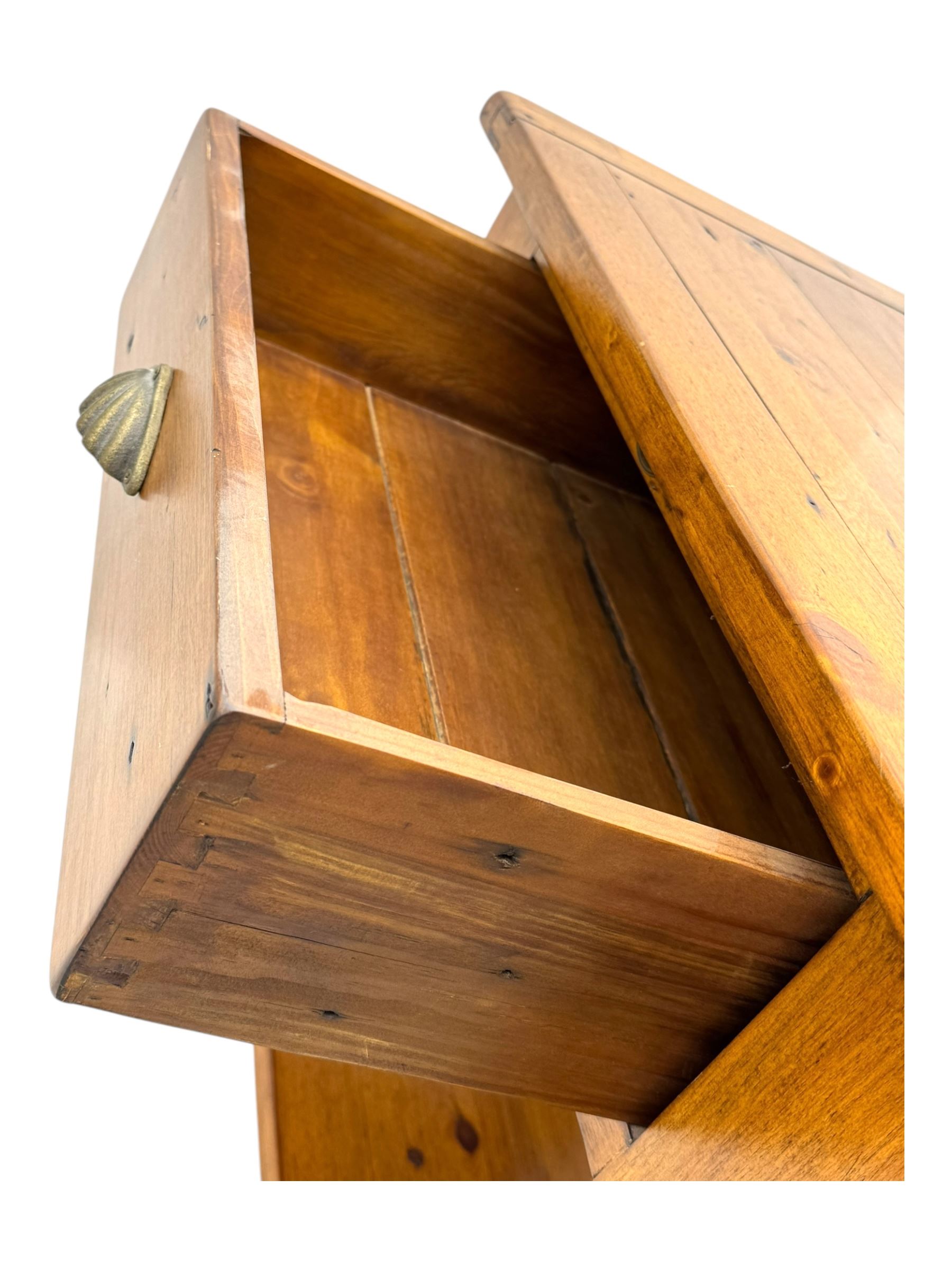 Contemporary hardwood lamp table, the rectangular boarded top over a single drawer with shell cup handle, standing on tapering supports united by undertier 