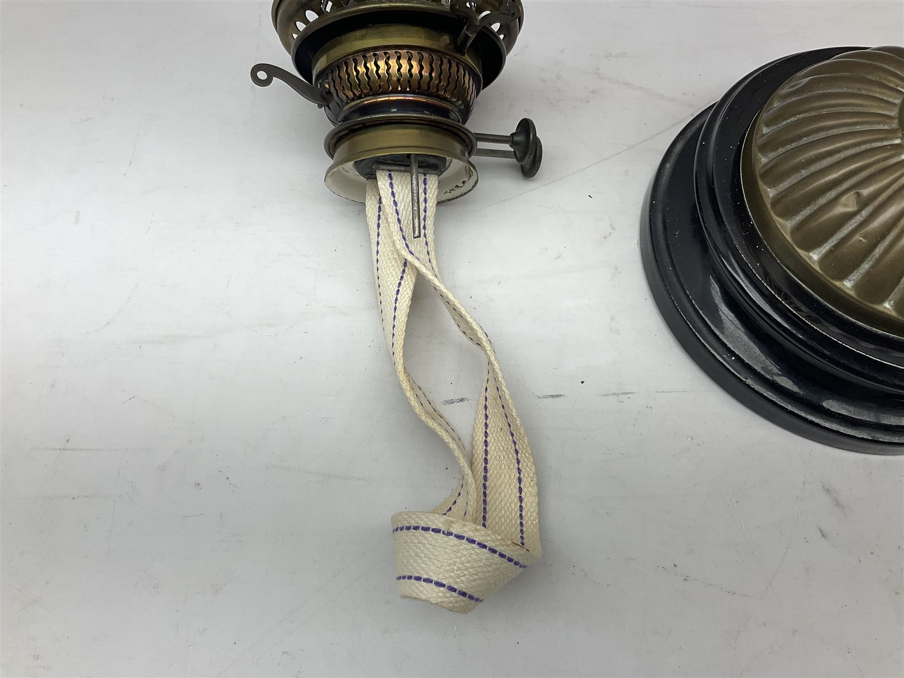 Victorian table oil lamp with black glazed stepped circular base, reeded brass column, moulded pink glass reservoir, duplex burner and frilled rim frosted glass shade with clear glass chimney H69cm