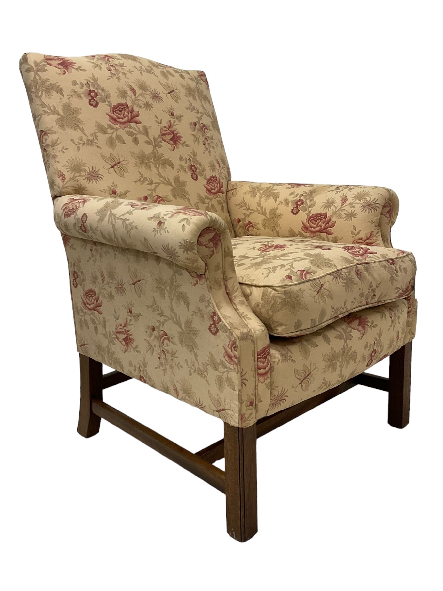 Peter Dudgeon - Georgian design mahogany framed armchair, shaped cresting rail over sprung back and seat flanked by rolled arms, upholstered in floral patterned fabric with matching seat cushion, on square supports joined by stretchers
Provenance: From the Estate of the late Dowager Lady St Oswald