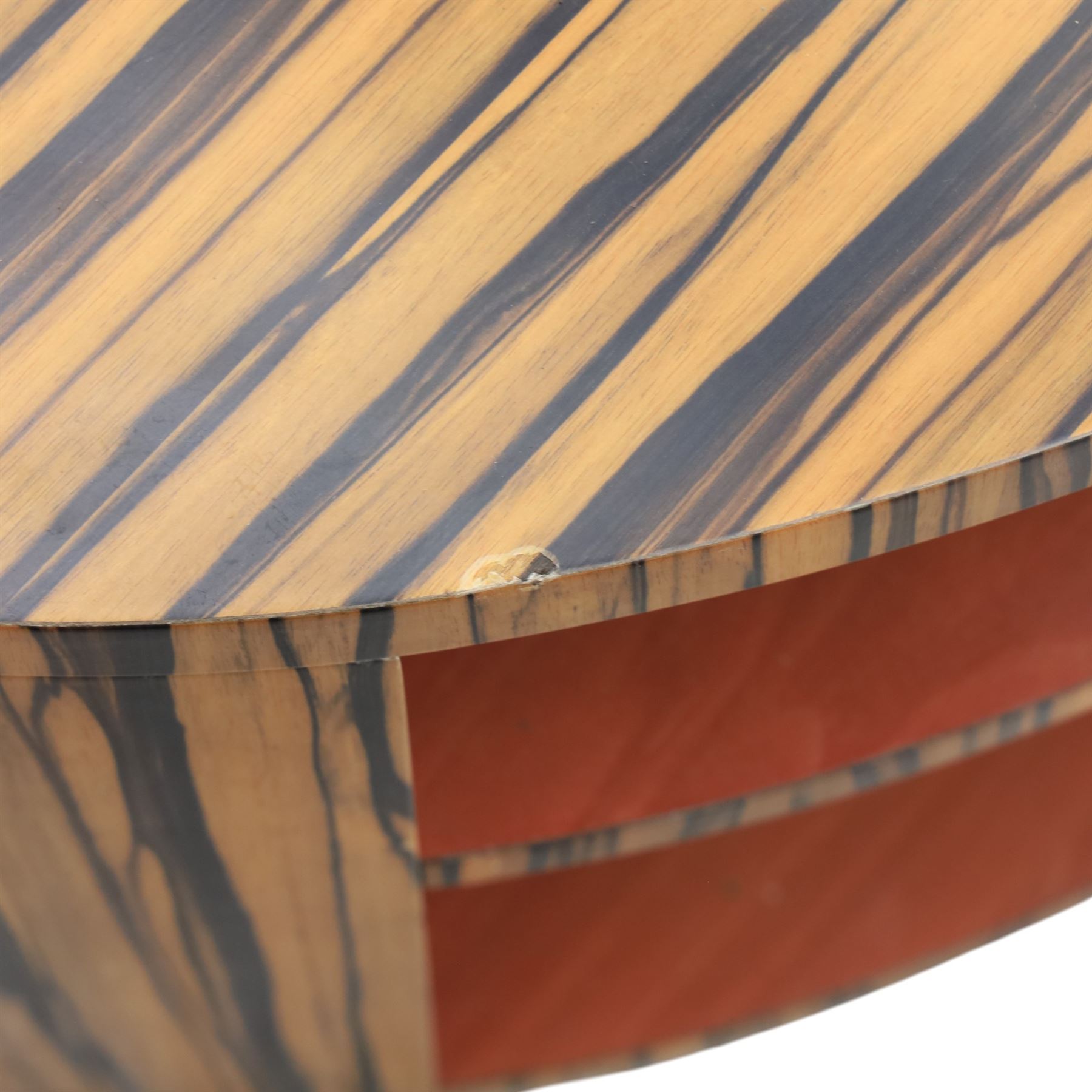 Toby Winteringham - Mid 20th century zebra wood coffee table, oval top with book matched striped veneers over two open tiers painted red, the curved end supports and continuous plinth base veneered to match, recessed plinth base 
