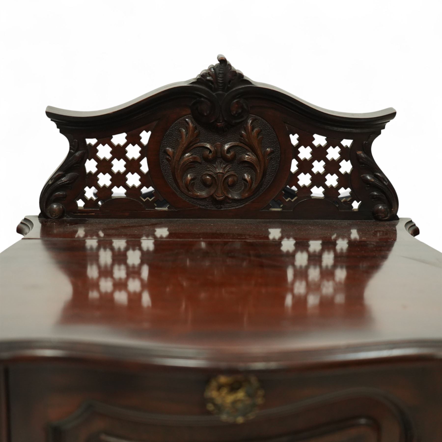 Late Victorian mahogany coal purdonium, the serpentine front door carved with scrolling foliage, surmounted by a pierced and foliate crest, brass carrying handles to sides, gilt metal mounts and cabriole legs