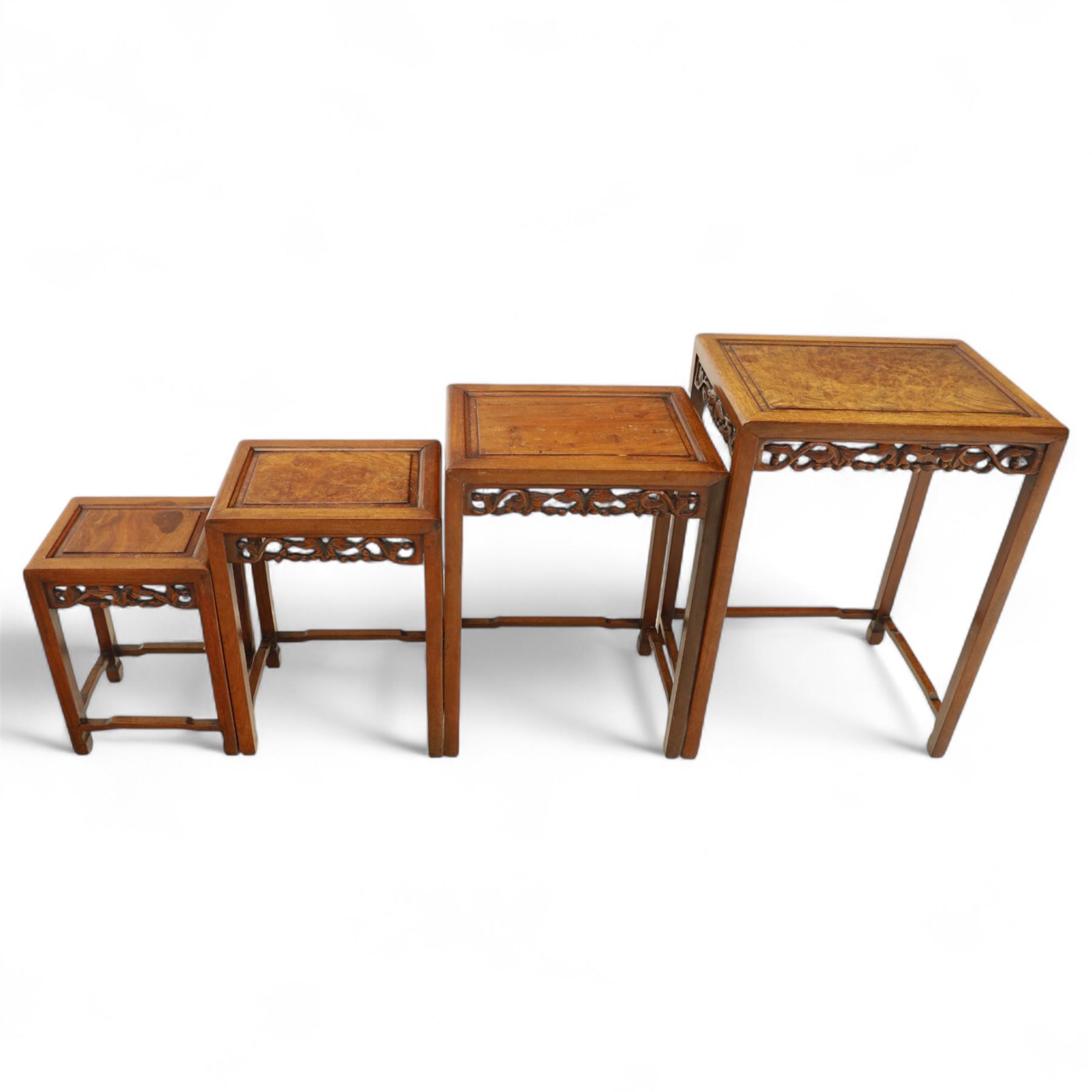 Early 20th century Chinese style hardwood quartetto nest of tables, each with panelled top and carved and pierced vine motif frieze, on square legs united by straight stretchers