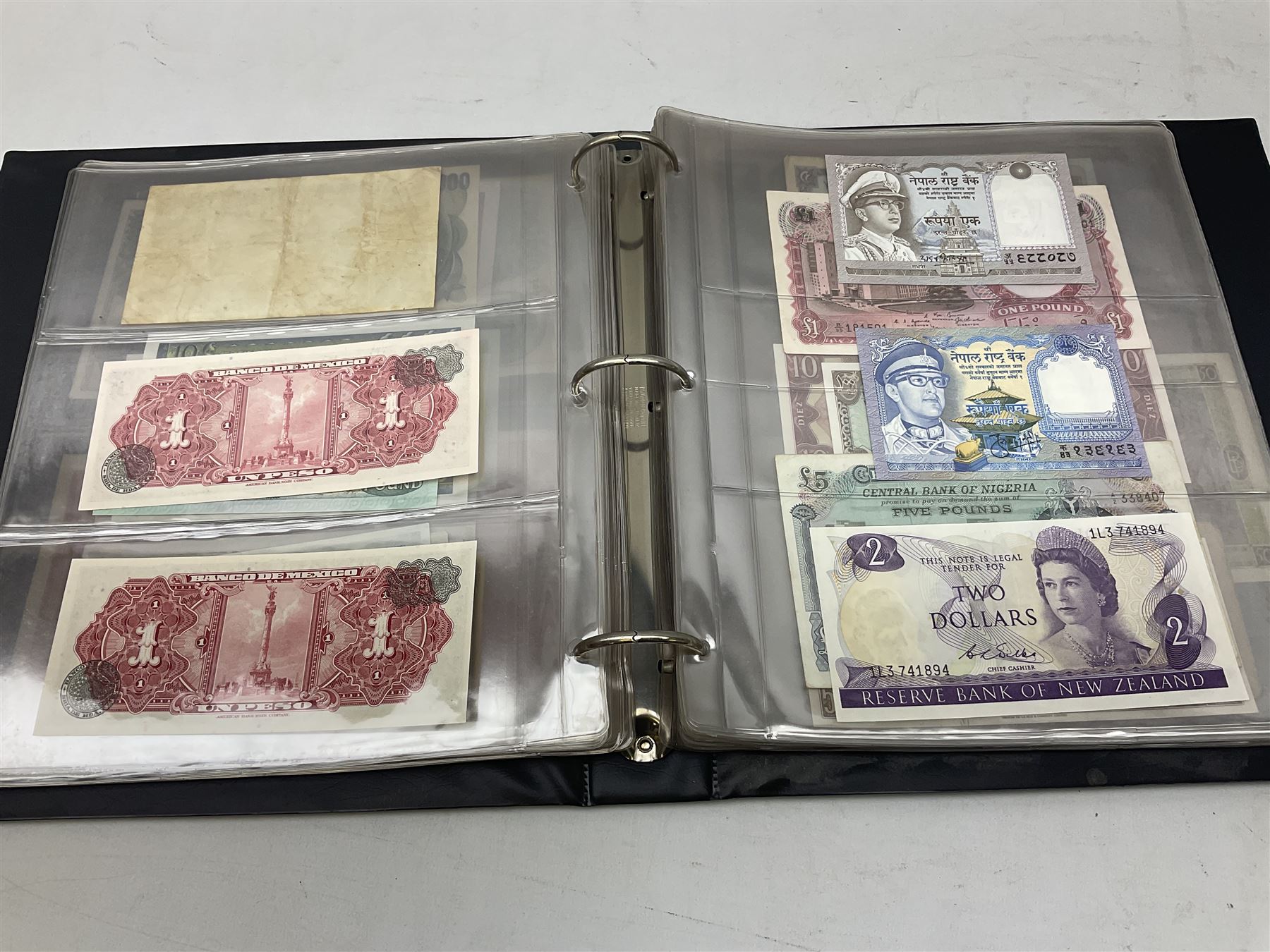 World banknotes, including Queen Elizabeth II The States of Jersey one pound 'DB202703', five pounds 'BB527762' and ten pounds 'AB651481', reserve bank of New Zealand two dollars '1L3 741894', King George V Straits Settlements one dollar 1st January 1935 'F/83 28924', various Bank of England notes etc, housed in two ring binder albums
