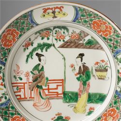 Chinese famille verte plate, painted with two ladies in a garden terrace setting, the border with butterfly and insect vignettes, D23cm 