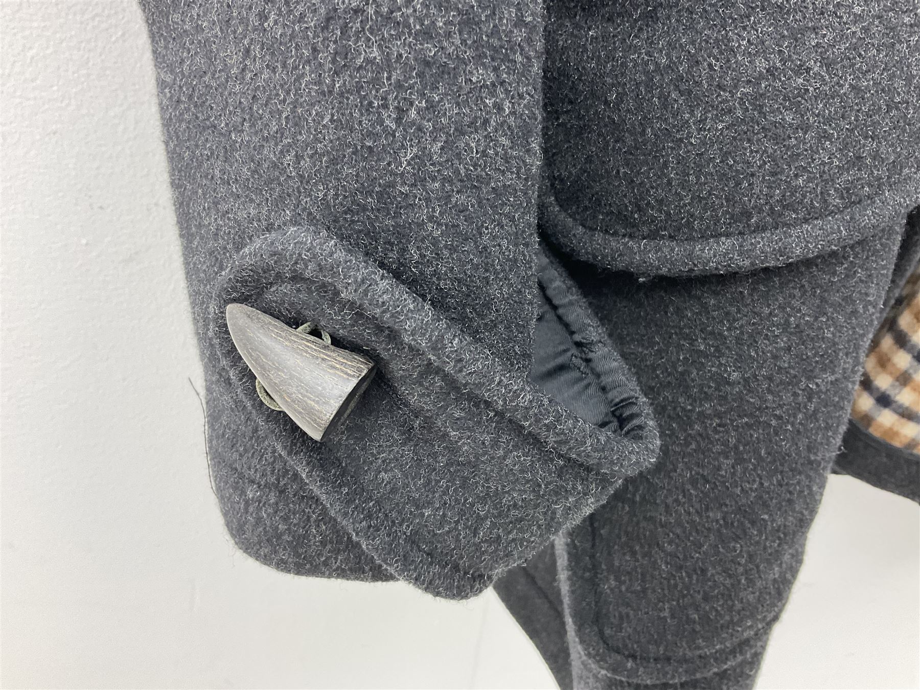 Men's Aquascutum lambs wool herringbone tweed coat with silk lining, 46 Reg, together with a further Men's Aquascutum grey wool duffle coat, with cheque lining and horn buttons, 46