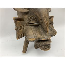 Carved African spirit mask,  having shaped facial features and a large carved  bird upon the head, H56cm