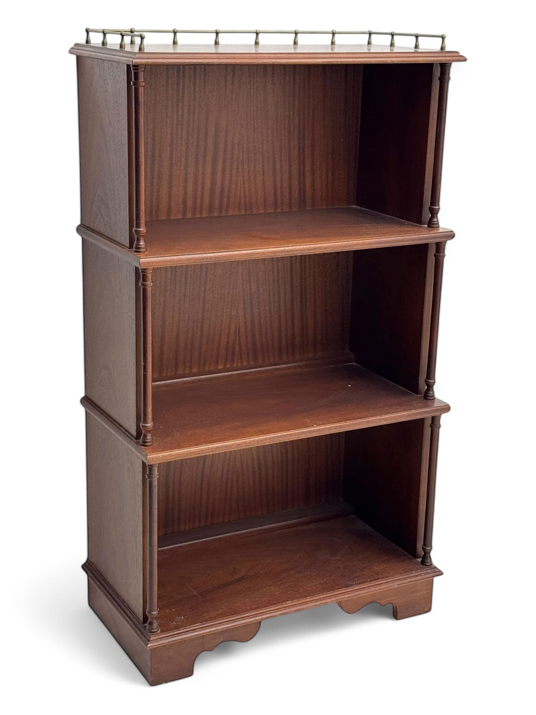Mid-20th century mahogany open bookshelf, the rectangular top with a brass balustrade gallery, over three shelves each supported by turned column uprights, on shaped apron base
