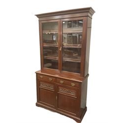 Late Victorian mahogany glazed bookcase on cupboard, projecting cornice, fitted with three shelves, base unit fitted with two long drawers and two cupboards